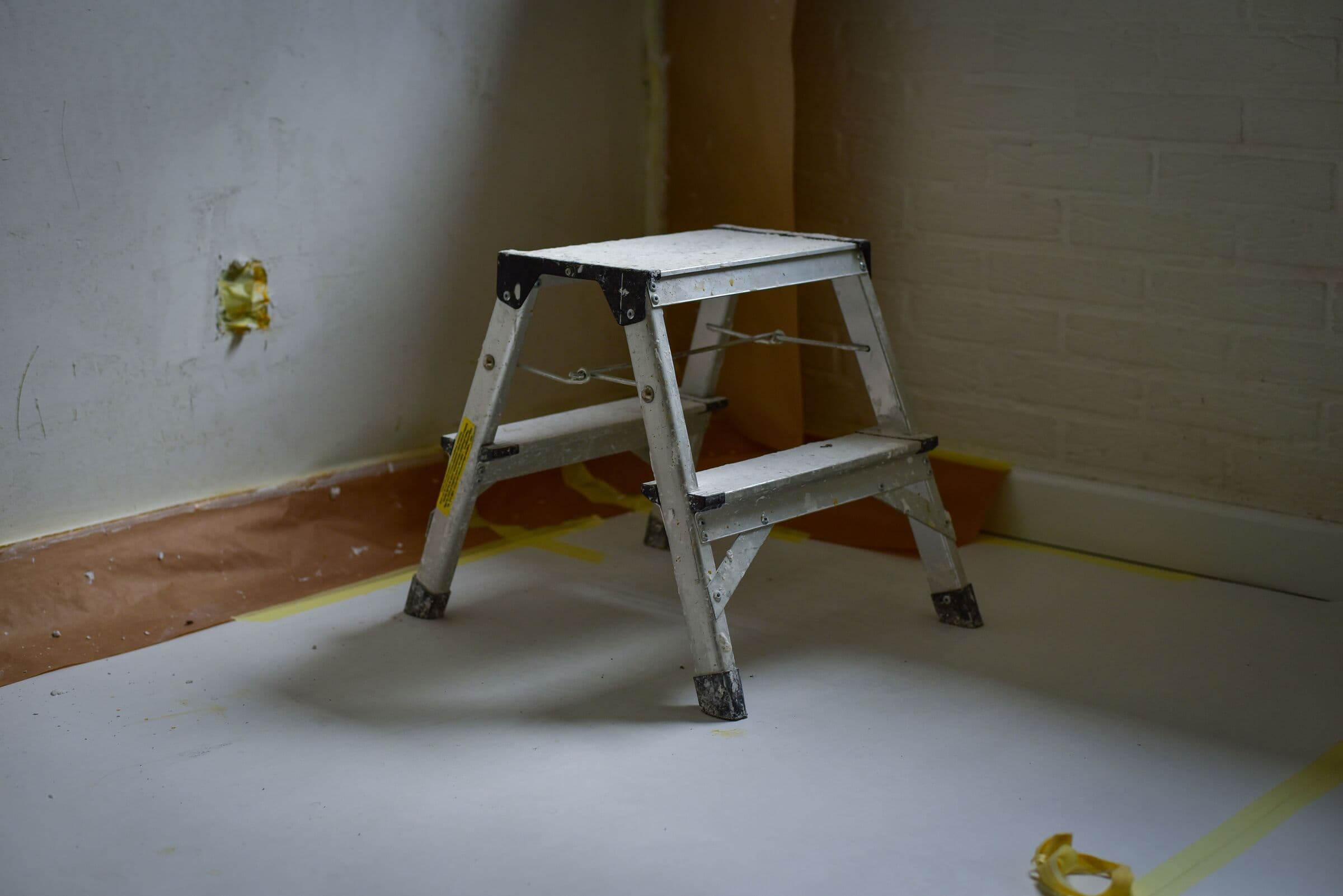Arbetsstege på ett skyddstäckt golv i ett rum under renovering